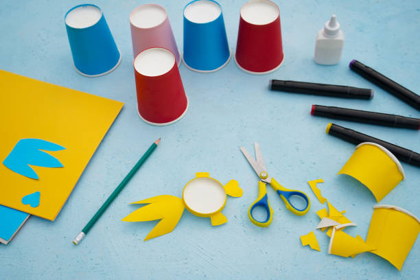 istock 5 - Step by step diy process. Kids craft multicoloured fish from a paper coffee cup, zero waste concept. 1744395014