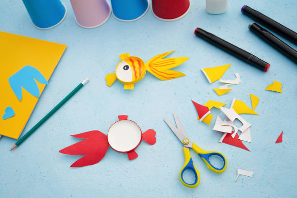 istock Step by step diy process. Kids craft multicoloured fish from a paper coffee cup, zero waste concept. 1744396811