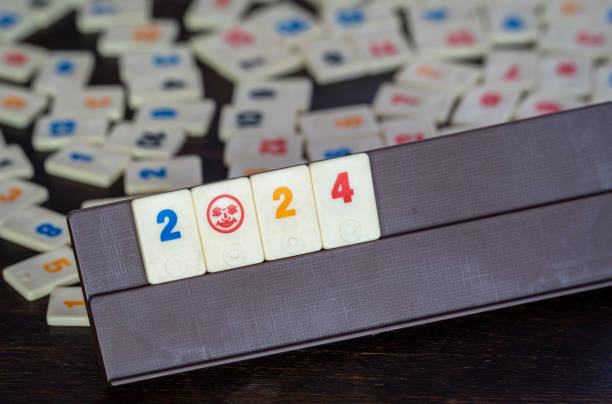 テーブルの上のルミクブタイル、ボードゲームで2024年の新年を待つ - rummy leisure games number color image ストックフォトと画像