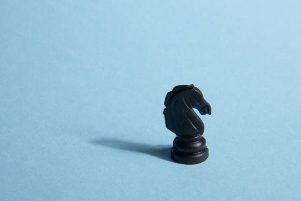 Business and leadership concept. Black chess knight on a blue background. Abstract background