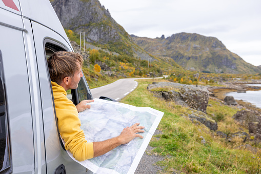 People travel, alternative homes concept. He looks at the beauty in nature.\nMan on a road trip with his camper van, he stops on the roadside to look at landscape