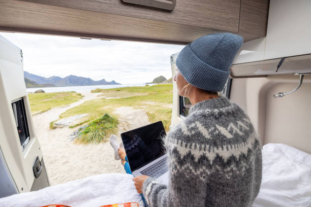 istock Road trip- Woman in a camper van working on laptop 1744444297