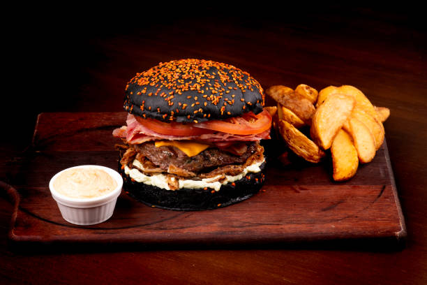 istock juicy classic burger with halloween themed black sesame bun with cheddar bacon crispy onion tomato rustic potatoes from above 1744457593