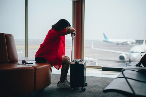 An asian woman upset and frustrated while flight canceled in airport