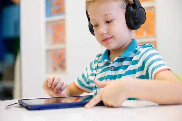 istock Preschool age boy wearing headphones and using tablet at audiometry session 1744466745