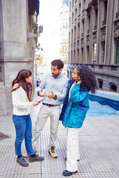 istock three young adults standing and talking socializing on the downtown street 1744470607