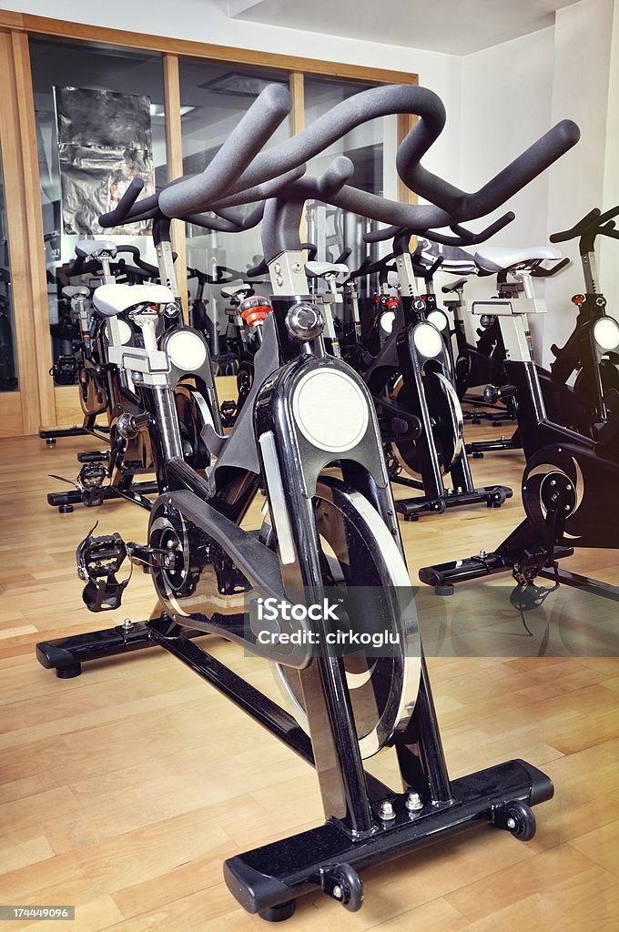 Grupo de bicicletas spinning en el salón de ejercicios - Foto de stock de Accesorio personal libre de derechos