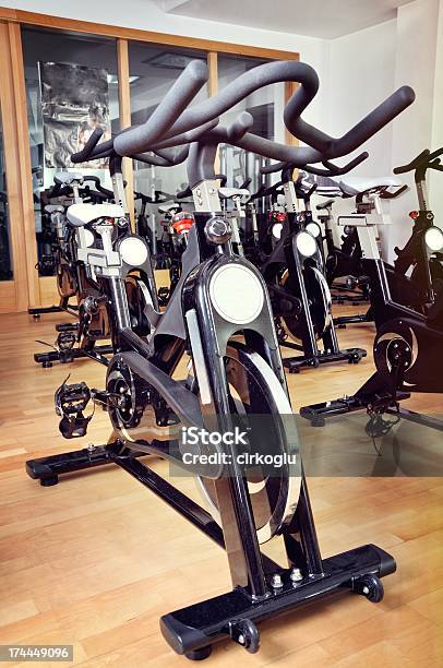 Grupo De Bicicletas Spinning En El Salón De Ejercicios Foto de stock y más banco de imágenes de Accesorio personal