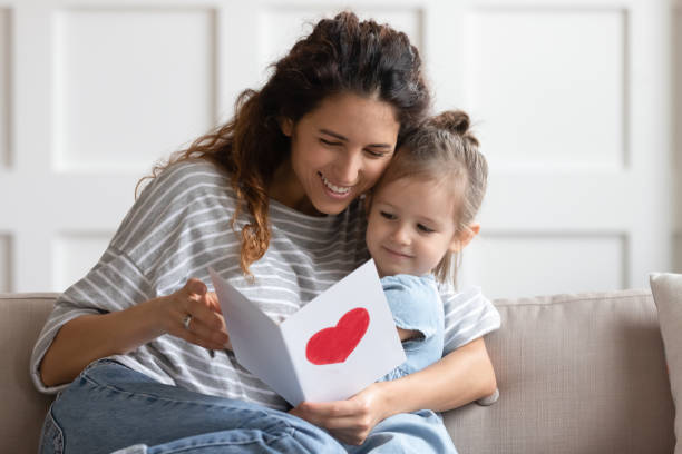 istock Cute little girl greeting mom presenting postcard 1744504604