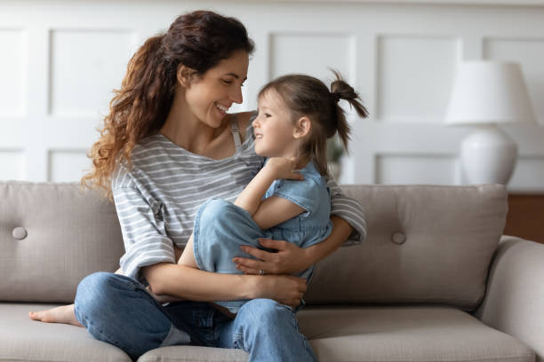 istock Smiling mother relax on sofa with little daughter 1744504932