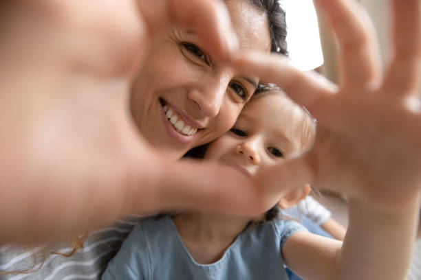 ritratto di mamma e figlia sorridenti fanno selfie insieme - 4 of a kind foto e immagini stock