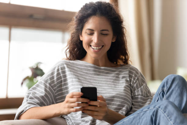 istock Smiling young woman have fun using modern cellphone 1744507853