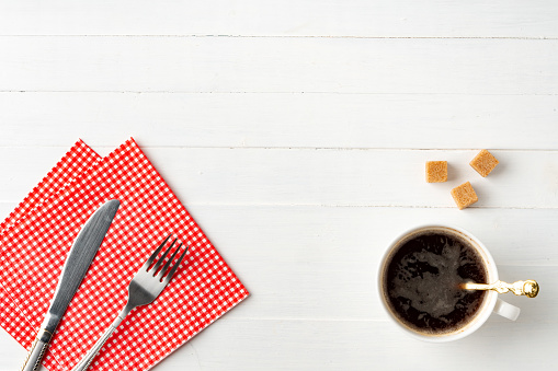 Top view photo of coffee cup and paper napkins on wooden background