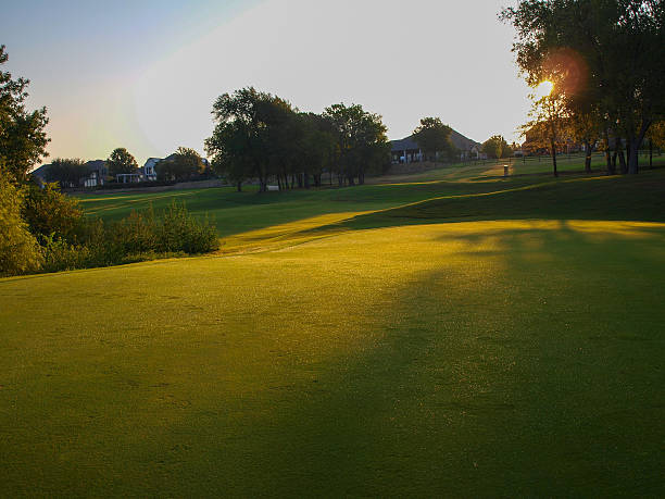 sonnenaufgang über dem 20. grün des golfplatzes - golf golf course sunrise morning stock-fotos und bilder