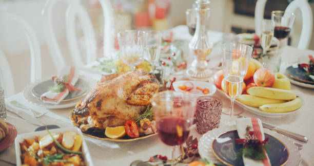 istock Tastefully Decorated Christmas Banquet Dining Table with a Grilled Chicken Dish, Vegetable and Fruit Garnishes, Baked Potatoes, Desserts and Drinks. Establishing Shot Without People 1744519629
