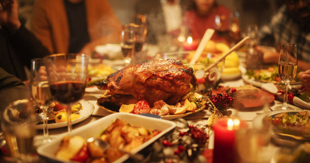 istock Tastefully Decorated Christmas Banquet Dining Table with a Grilled Turkey Dish, Vegetable and Fruit Meals, Baked Potatoes, Desserts and Drinks. Establishing Shot Without People 1744519663