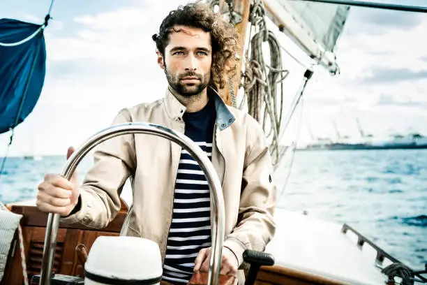 Portrait of young man sailing on a vintage boat