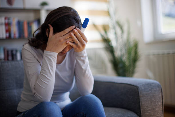 istock Unhappy woman holding her pregnancy test 1744523085