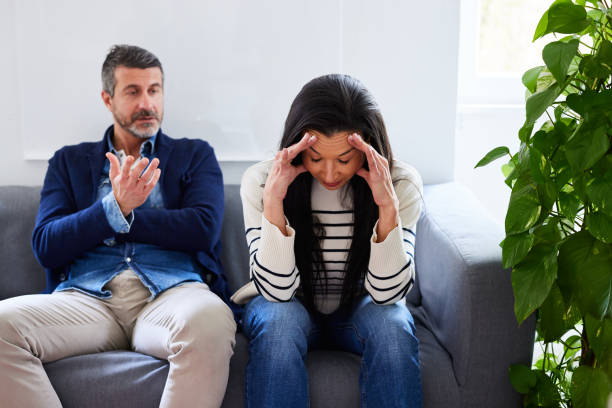 Husband blaming frustrated wife while sitting at doctor's office