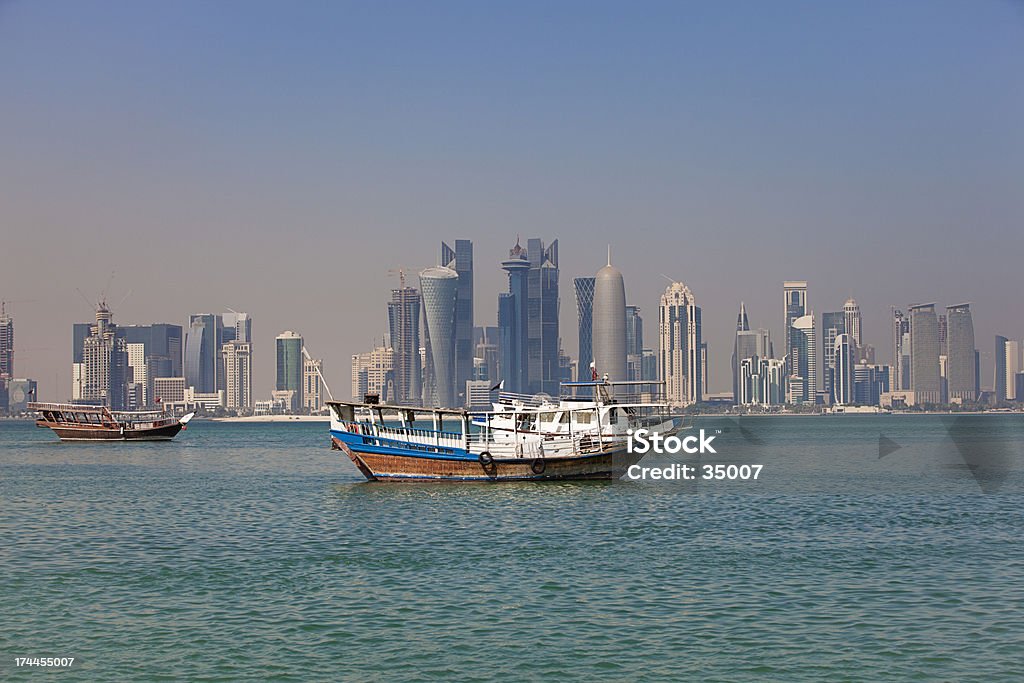 dhow and doha skyline A dhow returns to harbour in doha, qatar, with the city's modern skyline in the background. Arabia Stock Photo