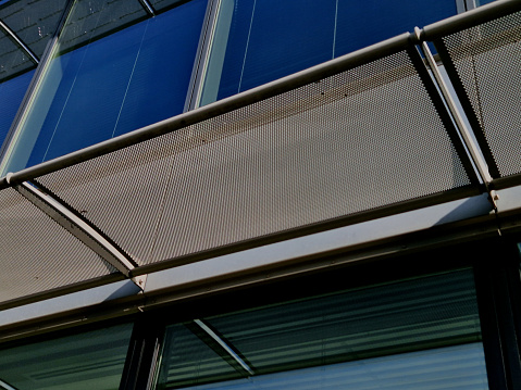 white tinted glass protects the interior from the sun. the glass strips are attached with metal screw holders to the tempered glass. blinds, designer light space of gallery or hotel, aluminium