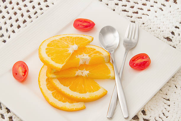 istock sliced oranges on white  plate with red tomato 174455324
