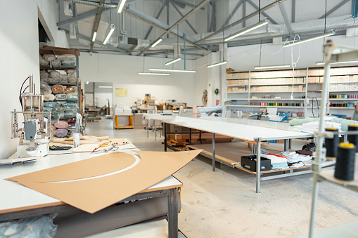 Interior of a sewing warehouse of furniture factory with equipment and materials background