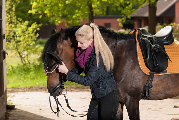 istock Girl bridles her horse 174455683