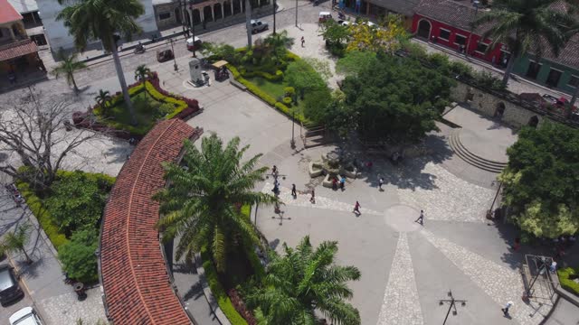 People walk in circular plaza of small Central Park in Copan, Honduras