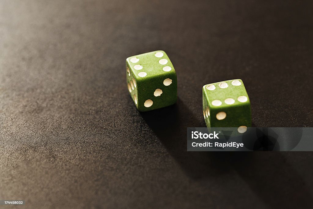 Green dice show score of 12 on black Green dice show the top score of 12, but it's still a gamble; luck can run out any time. Black background with copy space. Addiction Stock Photo