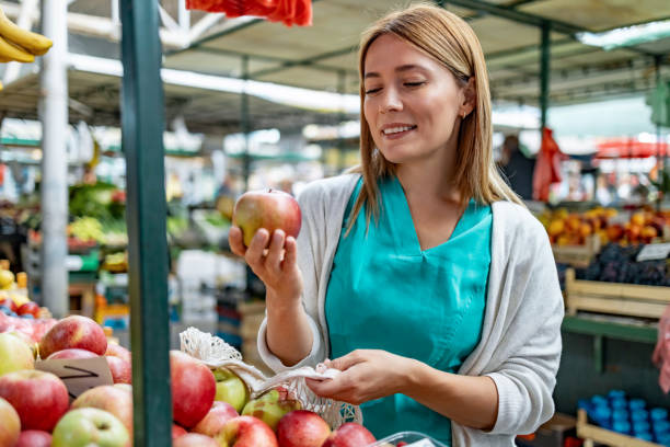istock Female customer choosing fresh apples on fruit display 1744581367