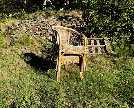 Old whicker chairs left in a field in the Pyrenees