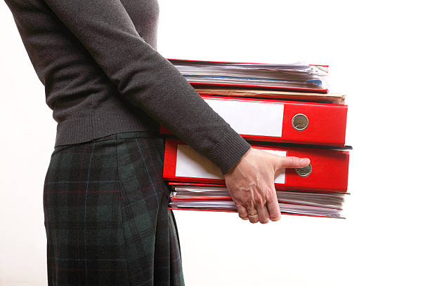 istock Female office worker carrying a stack of files 174462808