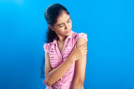 Asian teenage girl feeling shoulder joint pain