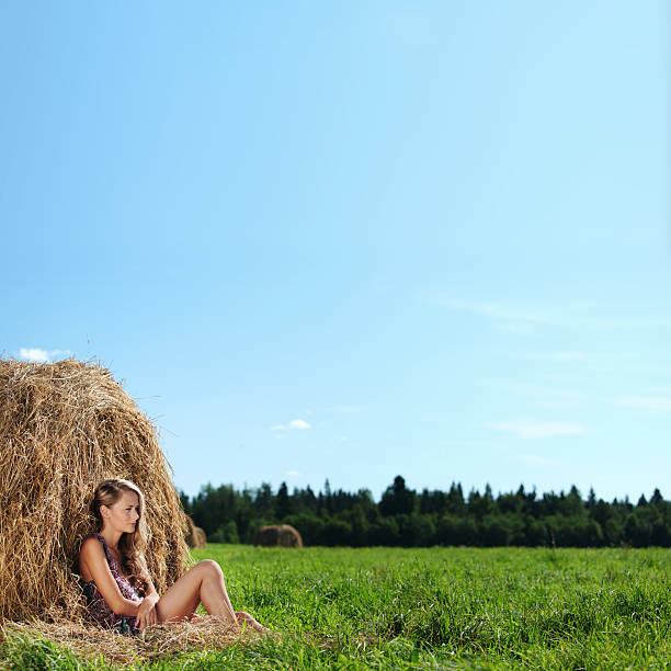 istock girl next to a stack of hay 174466430