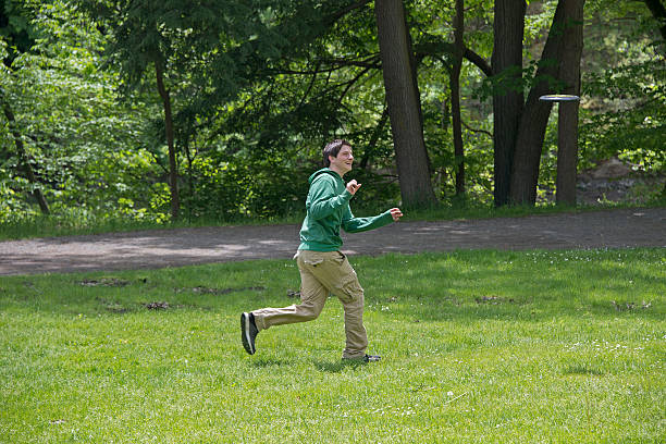 istock Young Man Playing Frisbee At The Park 174467046
