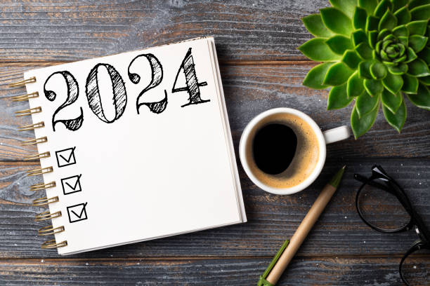istock New year resolutions 2024 on desk. 2024 resolutions list with notebook, coffee cup on table. Goals, resolutions, plan, action, checklist concept. New Year 2024 template 1744676741