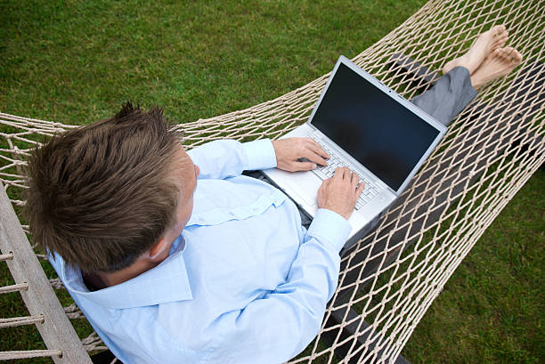 istock Businessman Types on Laptop in Hammock 174468163