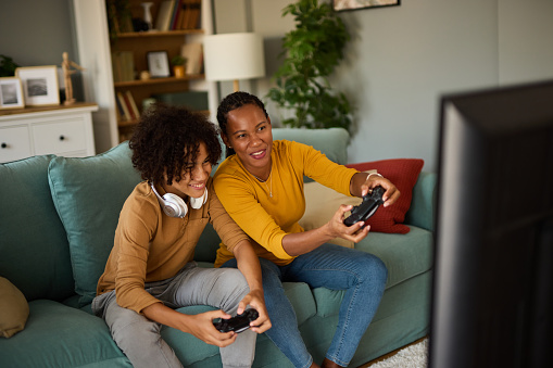 Mother and son playing video games at home