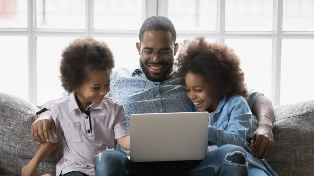 istock Close up smiling African American father with kids using laptop 1744696474