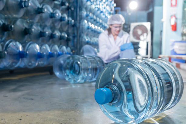 istock Close Up on Water Bottle with Blurred Injured Factory Workers 1744703562