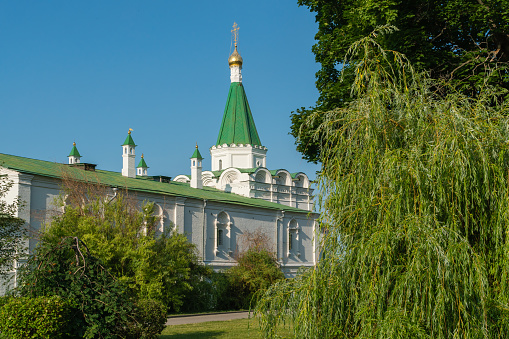 An ancient monastery built in the 14th century, traditional Russian architecture, stone chambers, temples and chapels, powerful white walls, domes and crosses, religious symbols, Orthodox Church, history and culture, trees and flowers, summer, travel and tourism.