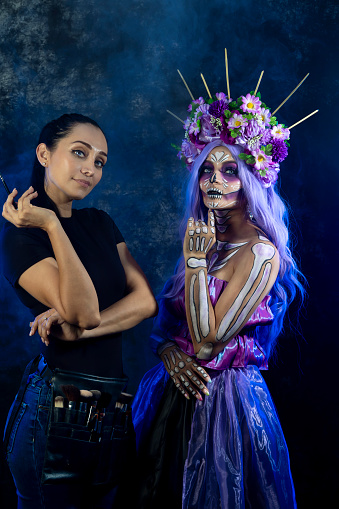 Portrait of catrina and make-up artist looking at the camera satisfied with their creative work.