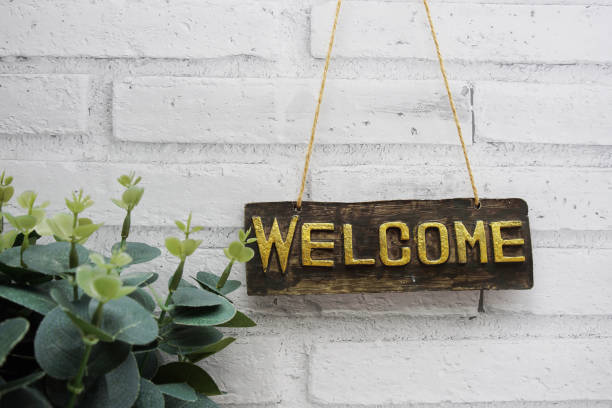 istock Welcome sign hanging with rope on white brick wall background 1744713998
