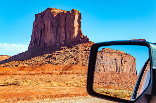 The car mirror reflects the scenic landscape. The famous colossal rock Camel. Navajo Indian Reservations. USA. Monument Valley is a unique geological formation in Arizona and Utah.