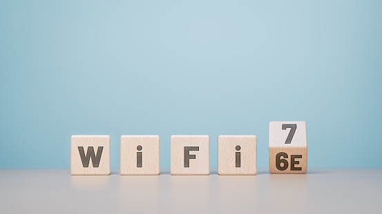 WiFi 6 to 7 symbol. Wooden cube blocks flipping from words WiFi 6e to WiFi 7. Transformation technology and to WiFi7 concept. Upgrade  router for high internet speed to support IoT and smartphones.