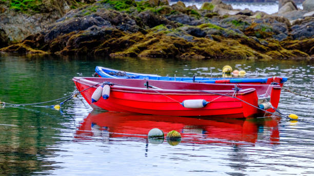 istock Small red boats moored in calm bay 1744727689