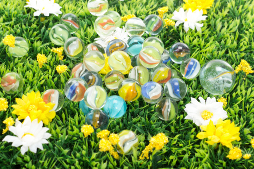 Lot of beautiful and colourful marbles on flower meadow