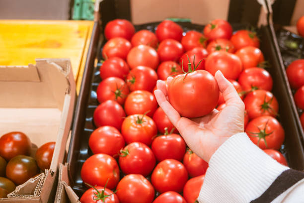 istock hand taking tomatoes from grocery store shelf 1744747546