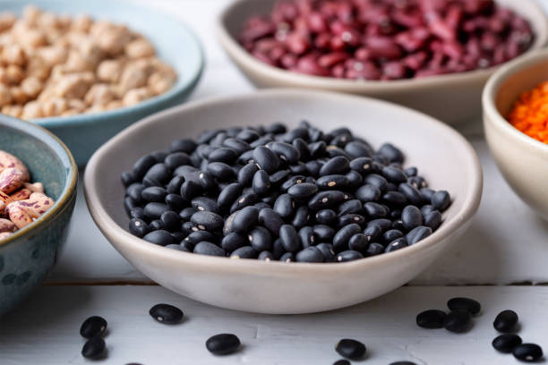 Different types of legumes in bowls - black beans